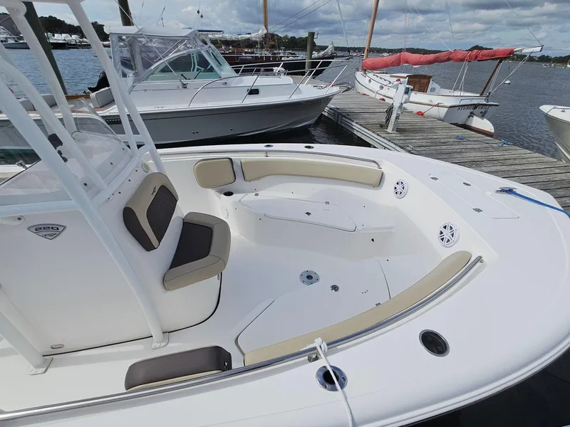 Slide: The Image of 2019 Tidewater 220 LXF boat docked, featuring spacious seating and sleek design. - 6
