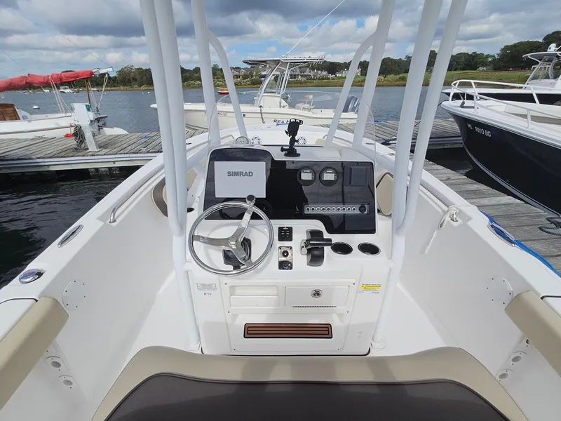 Slide: The Image of 2019 Tidewater 220 LXF boat console with steering wheel and Simrad display at dock. - 7
