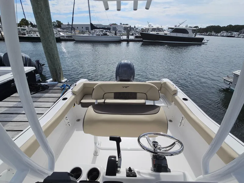 Slide: The Image of 2019 Tidewater 220 LXF boat interior at marina, featuring steering wheel and seating. - 8