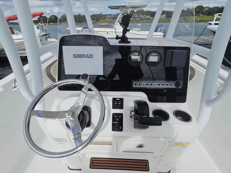 Slide: The Image of 2019 Tidewater 220 LXF boat dashboard with steering wheel and Simrad navigation system. - 9