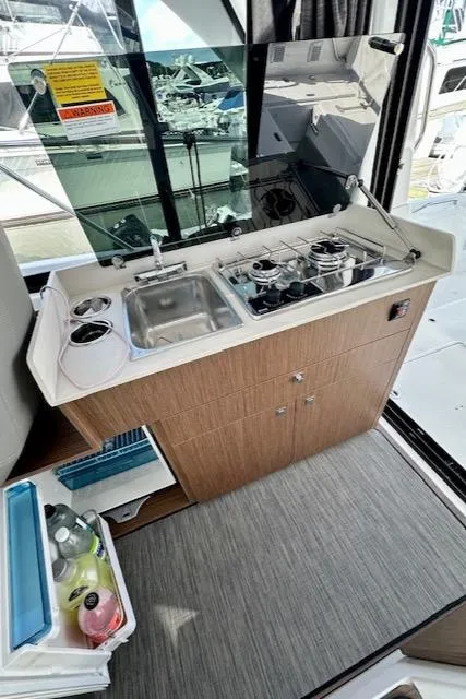 Slide: The Image of 2024 Beneteau Antares 9 yacht kitchen with sink, stove, and storage. - 15