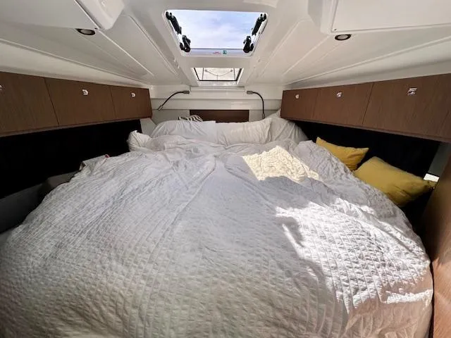 Slide: The Image of 2024 Beneteau Antares 9 cabin with cozy bedding and overhead skylight. - 16