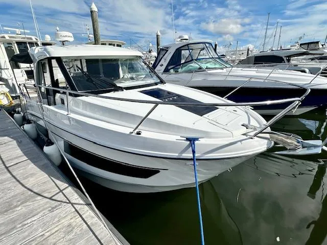 Slide: The Image of 2024 Beneteau Antares 9 docked at marina under blue sky. - 2