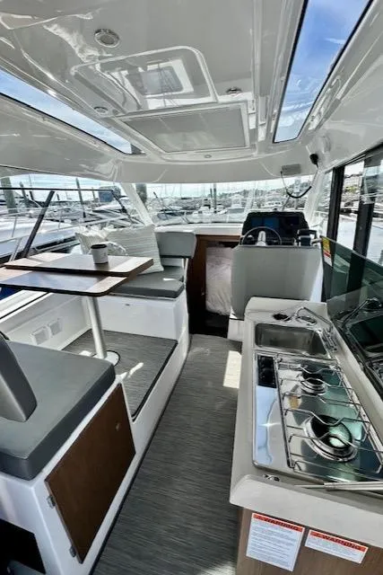 Slide: The Image of Interior of 2024 Beneteau Antares 9 boat, featuring modern seating and kitchen area. - 3