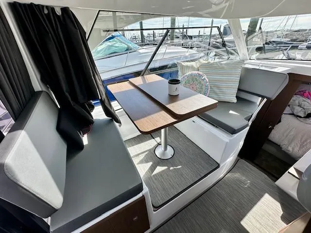 Slide: The Image of Interior of 2024 Beneteau Antares 9 with seating and table, docked at marina. - 4