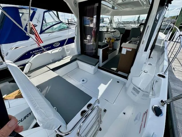Slide: The Image of 2024 Beneteau Antares 9 boat interior with seating and helm, docked at marina. - 6