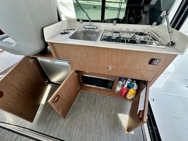 Slide: The Image of 2024 Beneteau Antares 9 boat kitchen with sink, stove, and storage cabinets. - 9