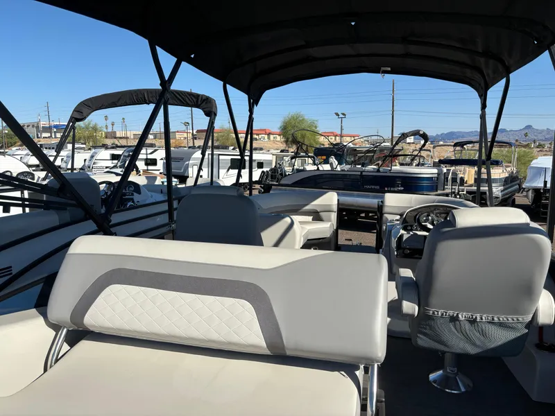 Slide: The Image of 2025 Lowe SS210DHCL pontoon boat with spacious seating and canopy in a marina setting. - 10