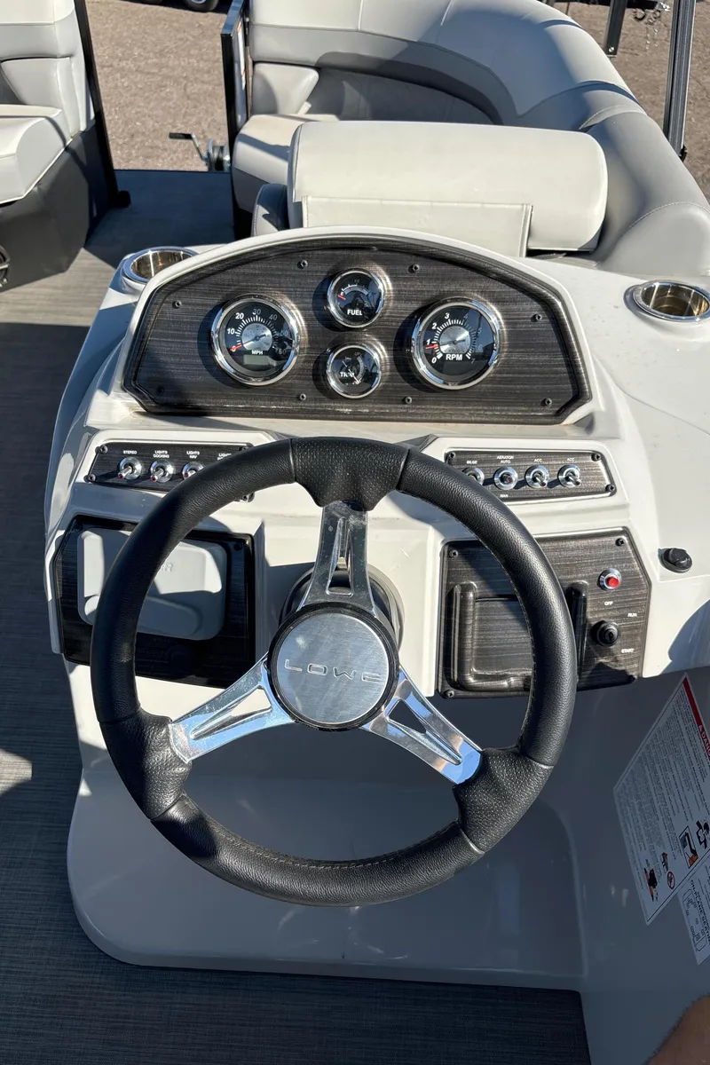 Slide: The Image of 2025 Lowe SS210DHCL boat dashboard with steering wheel and instrument panel. - 9