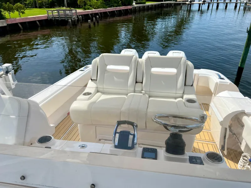 Slide: The Image of 2018 Intrepid 407 Cuddy boat interior with white seating and wooden deck. - 11