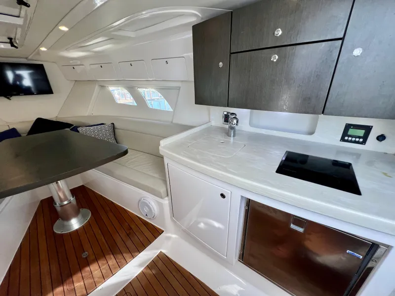 Slide: The Image of Interior of 2018 Intrepid 407 Cuddy with modern kitchen and seating area. - 14