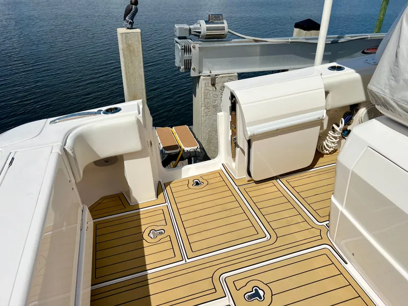 Slide: The Image of 2018 Intrepid 407 Cuddy boat deck with teak flooring and dock view. - 15