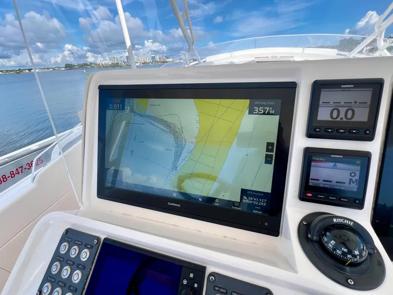 Slide: The Image of Intrepid 407 Cuddy 2018 boat dashboard with navigation screens and compass. - 18