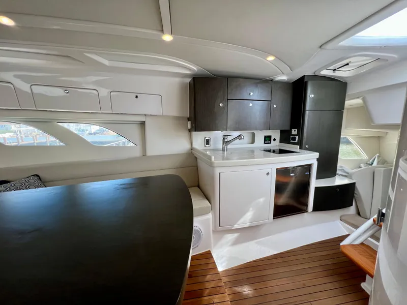 Slide: The Image of 2018 Intrepid 407 Cuddy interior with kitchenette and seating area. - 34