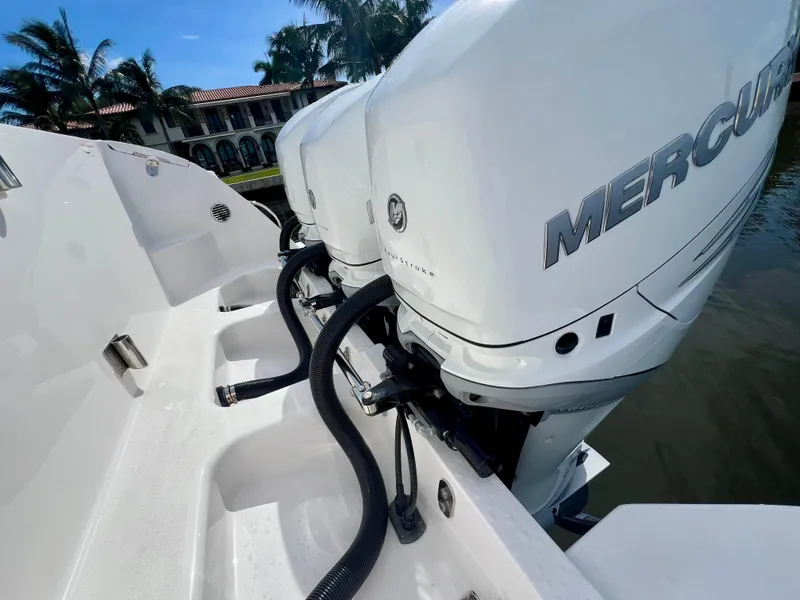 Slide: The Image of 2018 Intrepid 407 Cuddy with Mercury outboard engines, docked near luxury waterfront homes. - 49