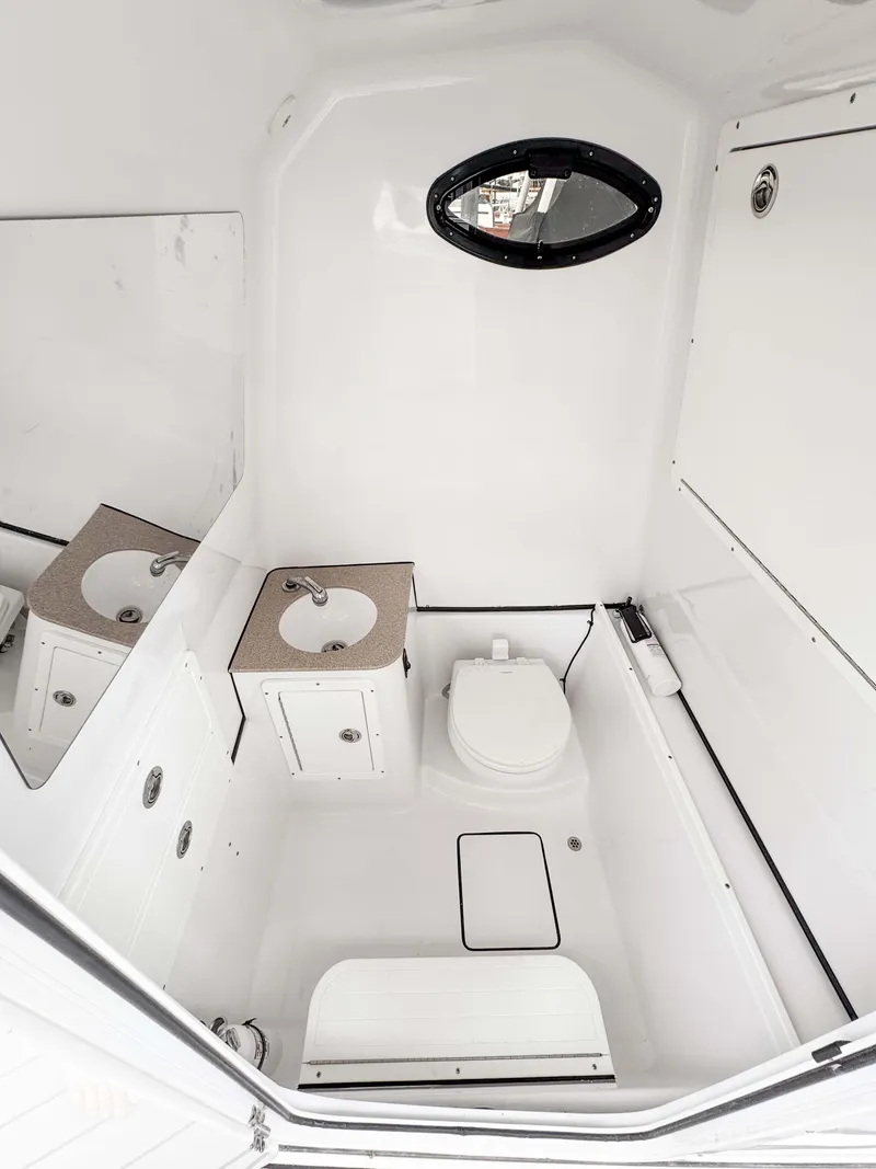 Slide: The Image of 2018 Sportsman Open 312 Center Console boat bathroom interior with sink and toilet. - 18