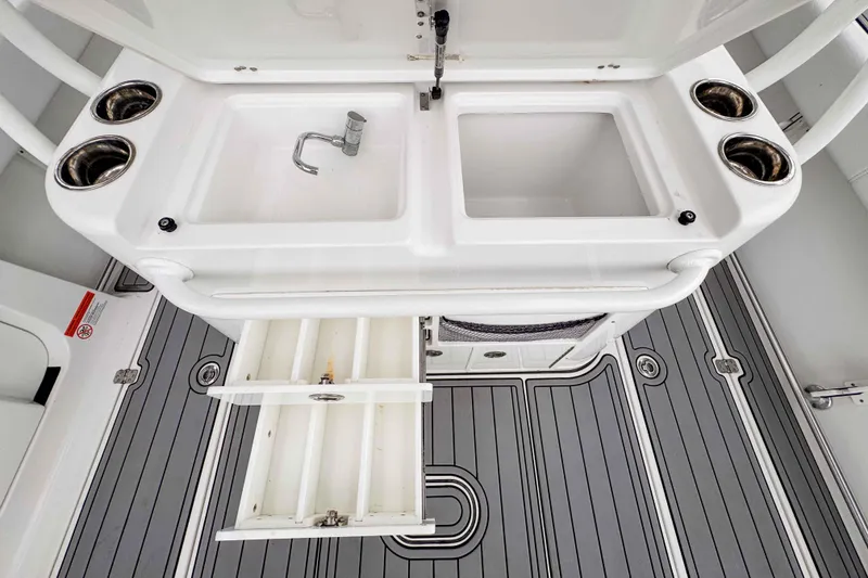Slide: The Image of 2018 Sportsman Open 312 Center Console boat interior with sink and storage drawers. - 25