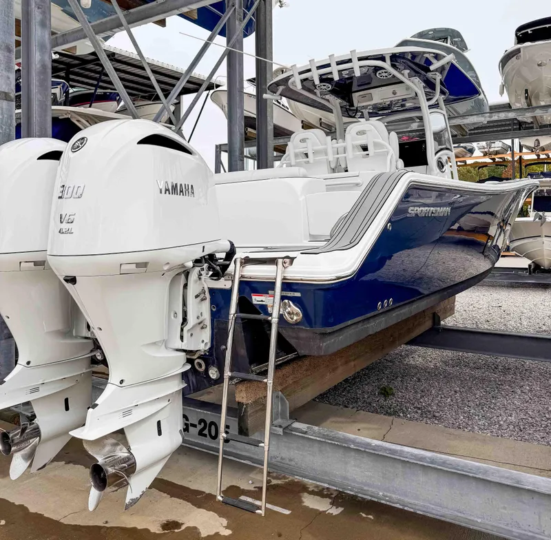 Slide: The Image of 2018 Sportsman Open 312 Center Console boat with twin Yamaha engines on a rack. - 5