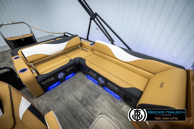 Slide: The Image of 2025 Avalon LSZ VRB boat interior with tan and white seating, blue LED lighting. - 24
