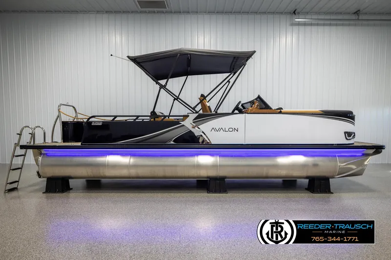 Slide: The Image of 2025 Avalon LSZ VRB pontoon boat with canopy and blue LED lights in showroom. - 5