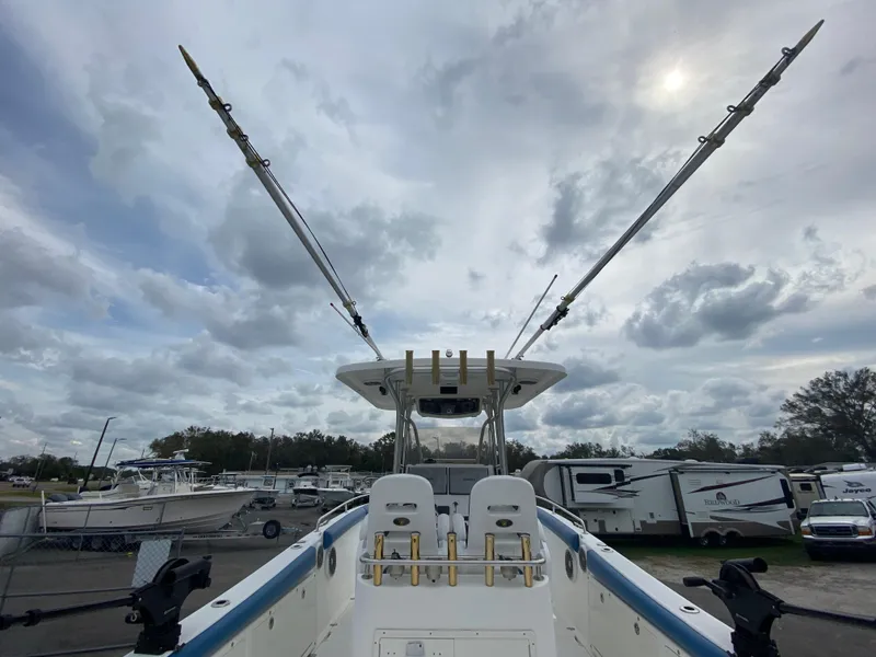 Slide: The Image of 2008 Century 2901 Center Console boat with outriggers, parked in a marina under cloudy skies. - 33