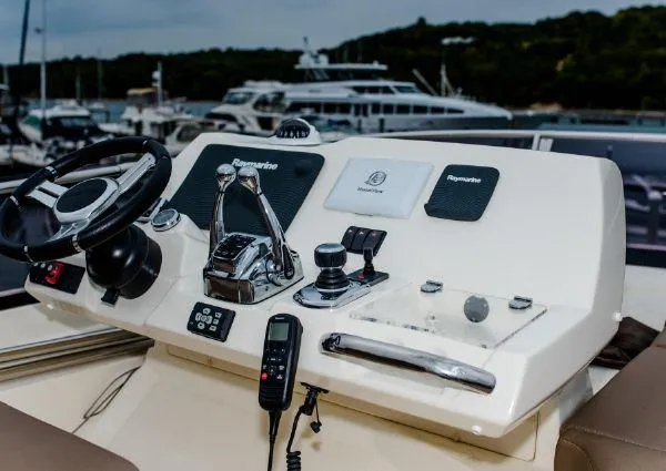 Slide: The Image of Control panel of a 2014 Prestige 550 yacht with steering wheel and navigation equipment. - 10