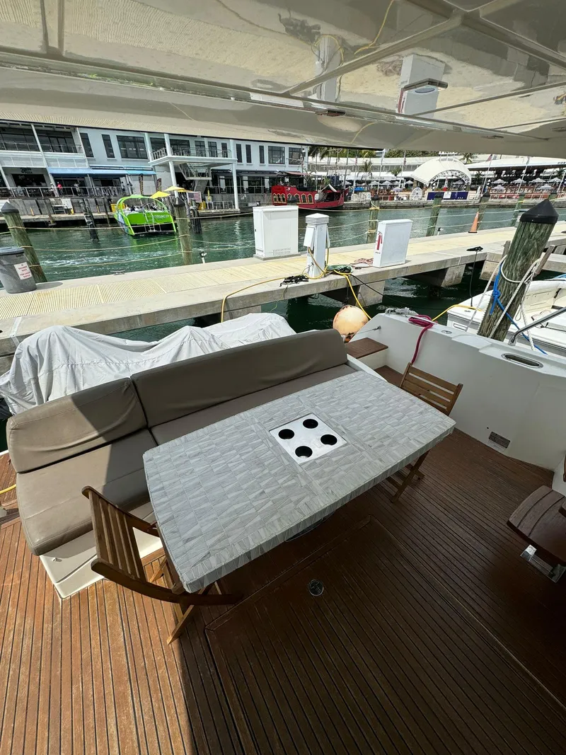 Slide: The Image of Prestige 550 yacht deck with seating and table, docked at marina, 2014 model. - 12