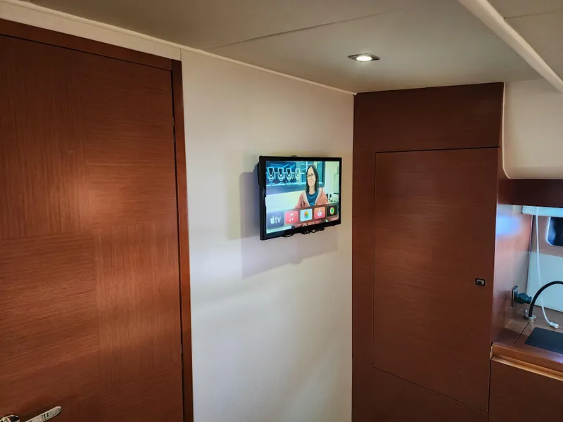 Slide: The Image of Interior of 2014 Prestige 550 yacht with wall-mounted TV and wooden cabinetry. - 27