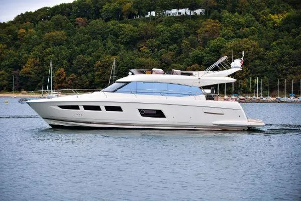 Slide: The Image of Luxury 2014 Prestige 550 yacht cruising on a serene lake with lush green backdrop. - 3