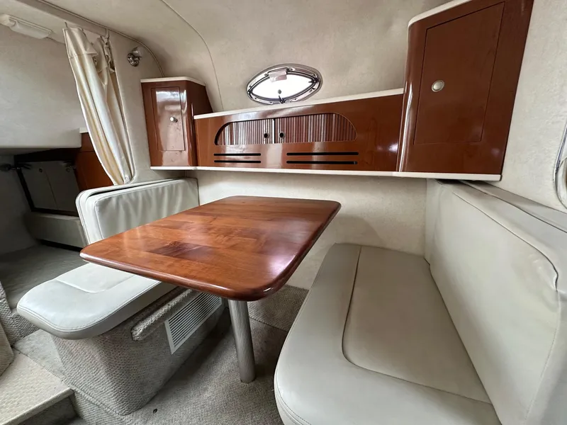 Slide: The Image of Interior of 2008 Sea Ray 280 Sundancer with wooden table and cushioned seating. - 14