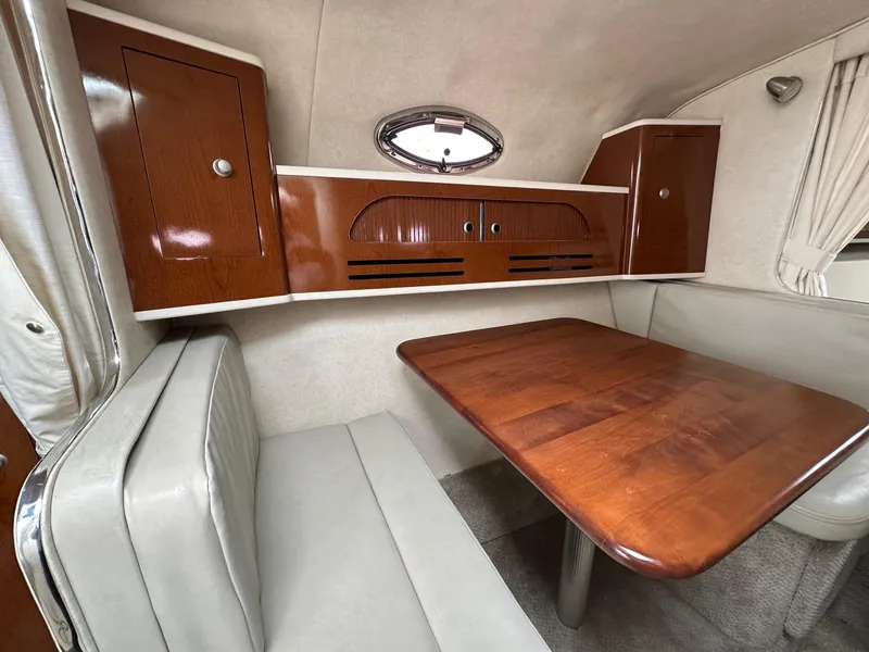 Slide: The Image of 2008 Sea Ray 280 Sundancer cabin interior with wooden table and storage cabinets. - 15