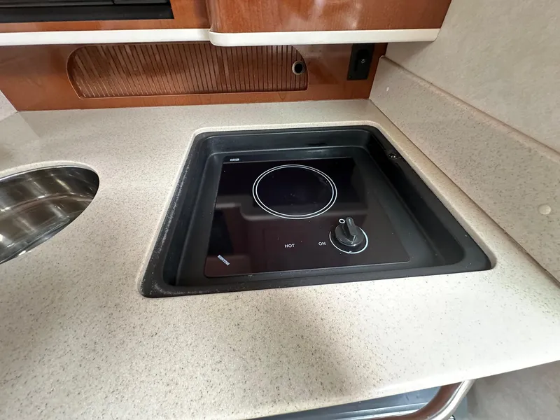 Slide: The Image of 2008 Sea Ray 280 Sundancer galley with electric cooktop and sink. - 16