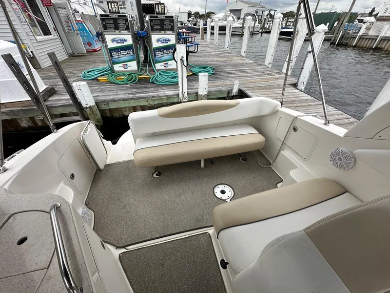 Slide: The Image of 2008 Sea Ray 280 Sundancer boat interior with beige seating at a marina dock. - 3