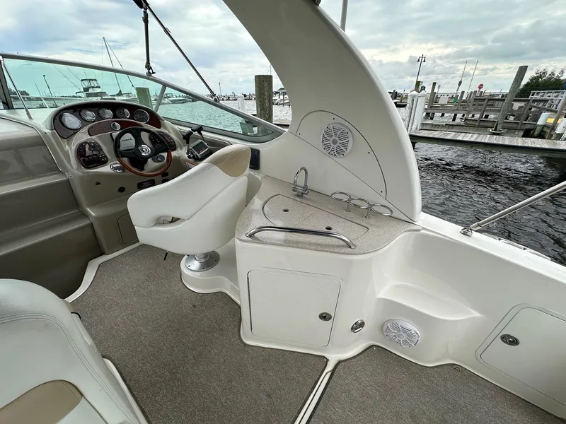 Slide: The Image of 2008 Sea Ray 280 Sundancer cockpit with helm, seating, and sink, docked at marina. - 4