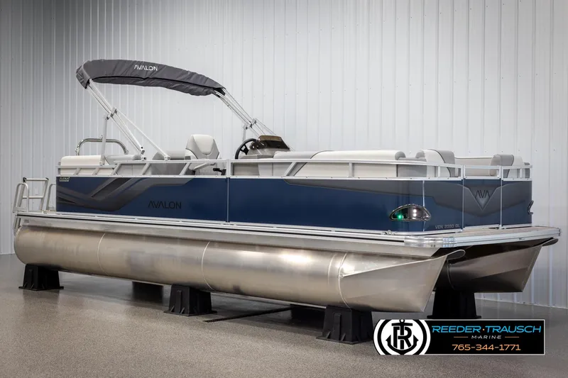 Slide: The Image of 2025 Avalon VEN QL pontoon boat in showroom, featuring sleek design and modern amenities. - 2