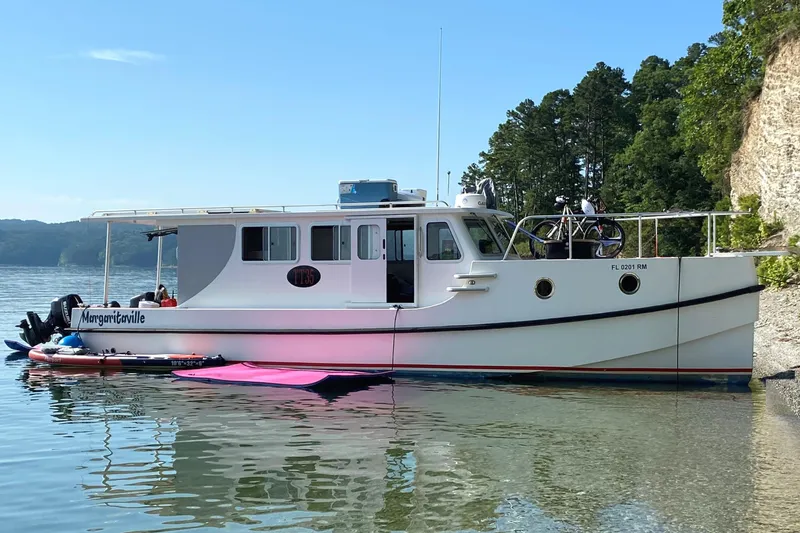 The Image of 2018 Great Harbour TT35 boat docked by a scenic shoreline with trees. - 0