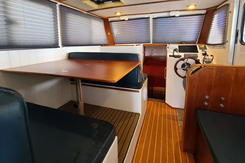 Slide: The Image of 2018 Great Harbour TT35 interior with dining area, helm, and wood accents. - 4