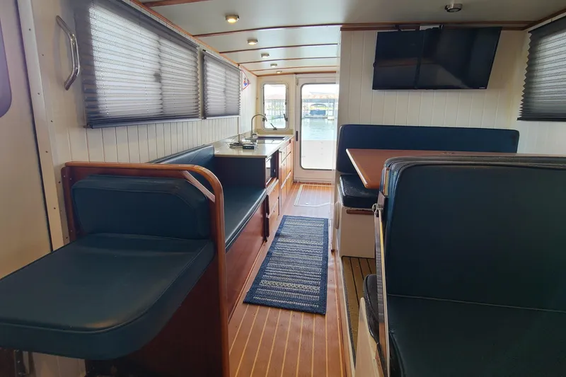 Slide: The Image of Interior of 2018 Great Harbour TT35 boat with seating, table, and TV. - 5