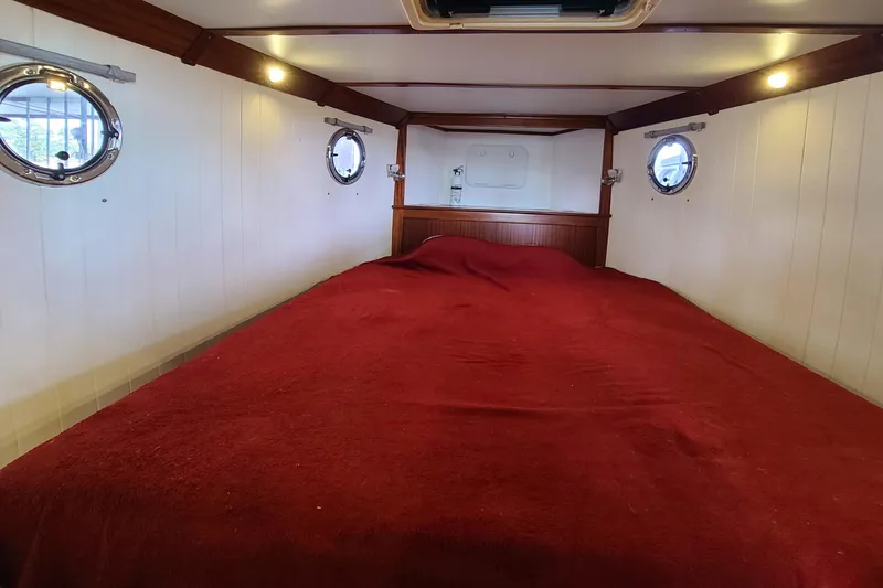 Slide: The Image of Cozy cabin interior of 2018 Great Harbour TT35 with red bedding and porthole windows. - 9