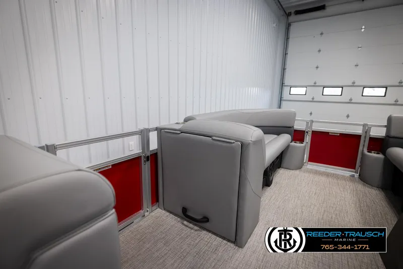 Slide: The Image of 2025 Avalon VLS QL boat interior with gray seating and red accents in a garage. - 20