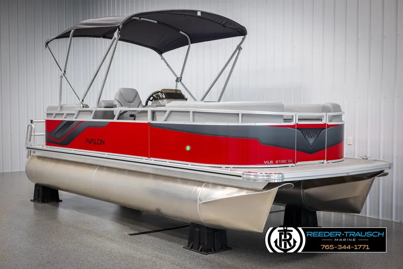 Slide: The Image of 2025 Avalon VLS QL pontoon boat with red and gray design in showroom. - 3