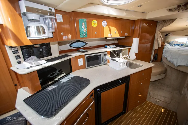 Slide: The Image of 2006 Maxum 3300 SE yacht interior with kitchenette, microwave, and bed. - 17