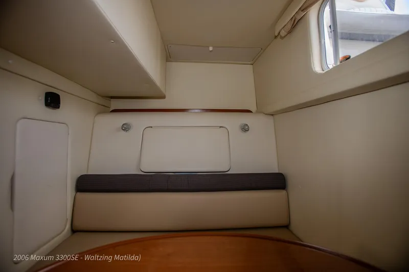 Slide: The Image of Interior cabin of 2006 Maxum 3300 SE boat, featuring cozy seating and window. - 25