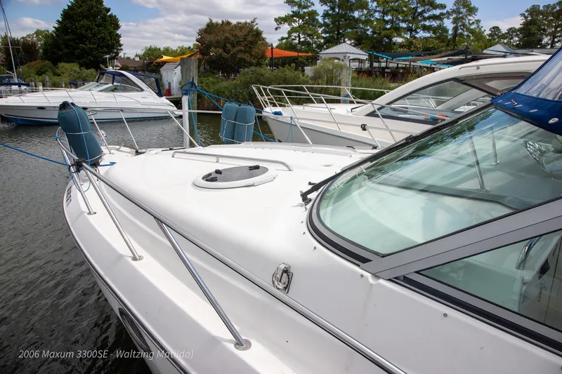 Slide: The Image of 2006 Maxum 3300 SE boat docked in a marina, surrounded by other vessels. - 28