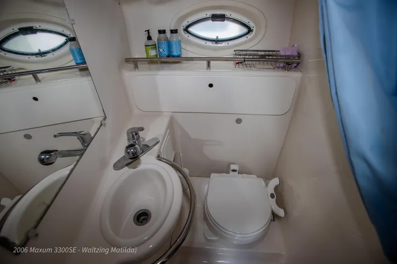 Slide: The Image of 2006 Maxum 3300 SE boat bathroom with sink, toilet, and porthole window. - 3