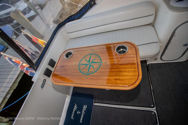 Slide: The Image of 2006 Maxum 3300 SE boat interior with compass design table and seating. - 32