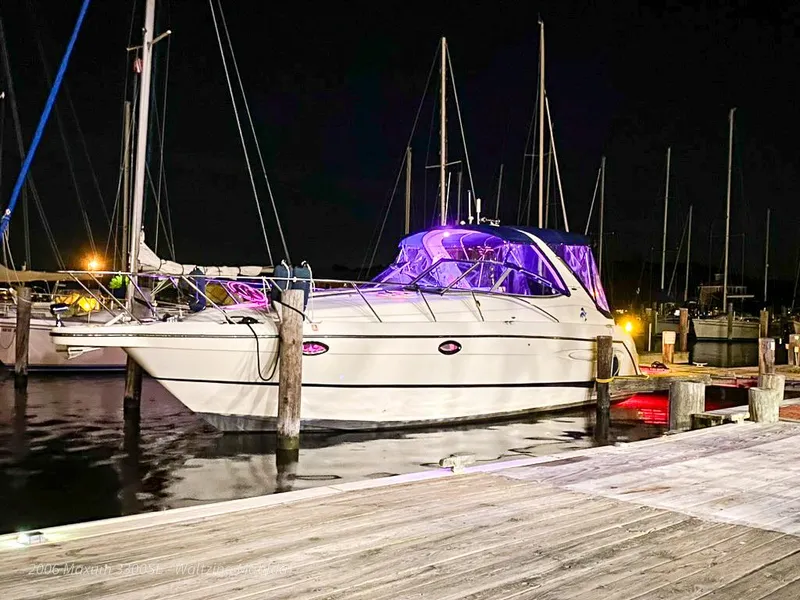 Slide: The Image of 2006 Maxum 3300 SE yacht docked at night with purple lighting. - 34