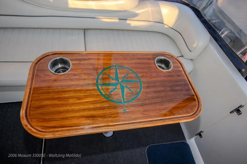 Slide: The Image of 2006 Maxum 3300 SE boat interior with wooden table and compass design. - 42