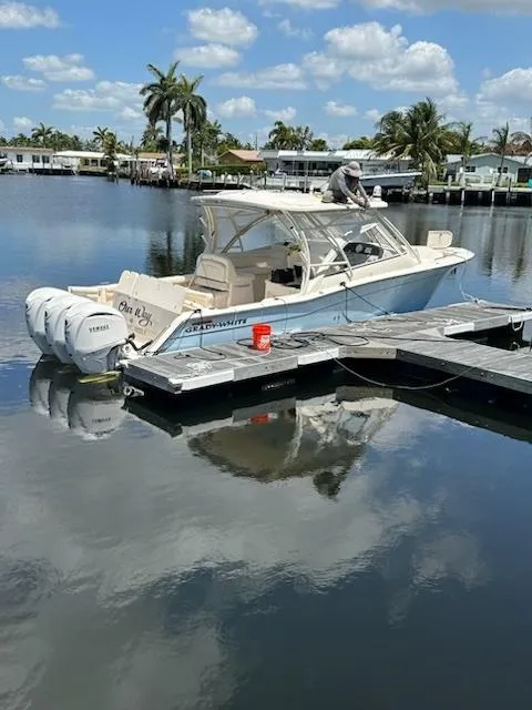 Slide: The Image of 2023 Grady-White Freedom 335 boat docked on a calm, sunny waterfront. - 1