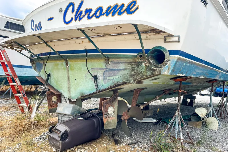 Slide: The Image of 1978 Bertram 46 Convertible boat on stands, undergoing maintenance, with visible propellers and ladder. - 11